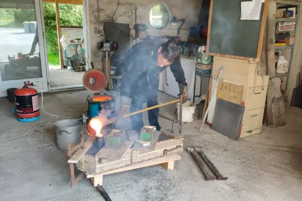 artisan fondeur Vincent Guillois coule une épée en bronze.