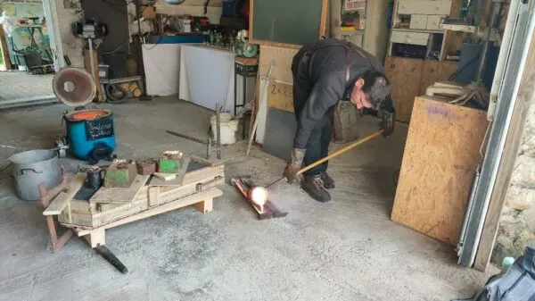 artisan fondeur Vincent Guillois coule une épée en bronze.